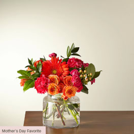 Bouquet of orange and pink flowers in a clear glass vase