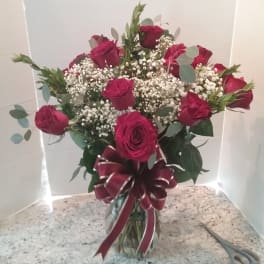 Bouquet of red roses with baby's breath in a glass vase