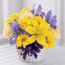 Yellow and purple mixed flower basket with a ribbon bow