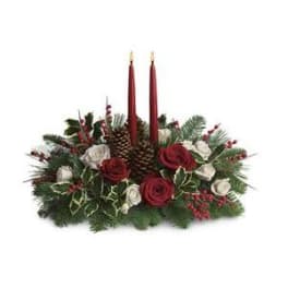 Holiday centerpiece with red candles, roses, and pinecones