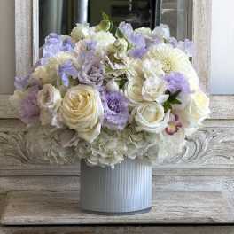 Pastel bouquet of white and lavender flowers in a ribbed vase