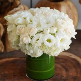 White roses and lisianthus in a green vase
