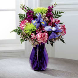 Colorful bouquet in a purple vase with iris and carnations