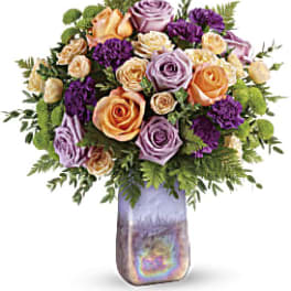 Bouquet of peach, lavender, and purple roses in a tall iridescent vase