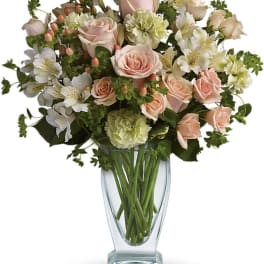 Bouquet of pale pink roses and white alstroemeria in a clear glass vase
