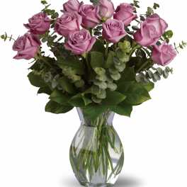 Pink roses arranged in a clear glass vase with eucalyptus