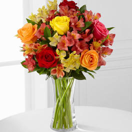 Mixed bouquet of roses and alstroemeria in a clear glass vase