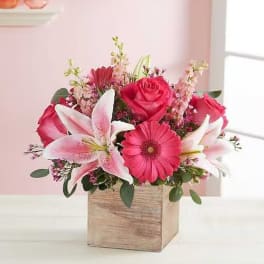 Pink and white flower arrangement in a wooden box