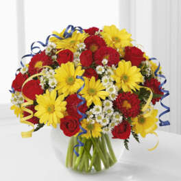 Bouquet of red roses and yellow daisies with blue ribbon curls in a glass vase