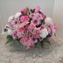 Pink and white floral arrangement with a pink ribbon and "sister" sign