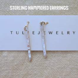 Pair of hammered silver drop earrings on a jewelry card