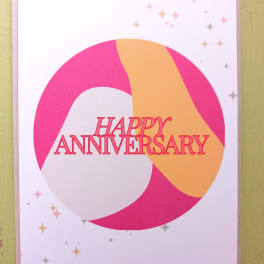 Happy anniversary greeting card with pink and peach abstract circle design and small star accents