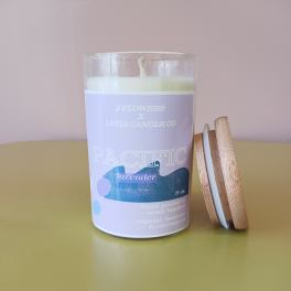 Lavender candle in a glass jar with a wooden lid beside it
