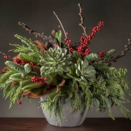 Succulent arrangement with red berries in a gray vase