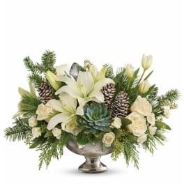 White lilies and roses arranged with pinecones in a silver bowl vase