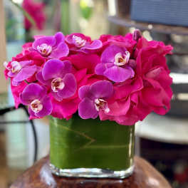 Pink roses and purple orchids in a glass vase