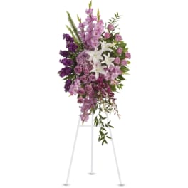 Tall purple and white floral standing spray on a white easel