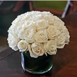 White rose bouquet in a dark green glass vase