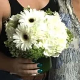 White gerbera daisies and pale blooms in a green vase