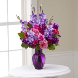 Purple and pink bouquet in a purple glass vase