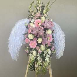 Pink and white floral standing spray with feathered white wings
