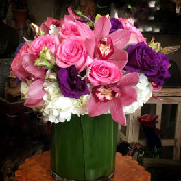 Pink and purple flower arrangement in a green vase