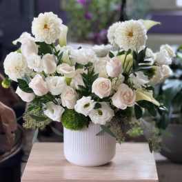White floral arrangement in a ribbed white vase