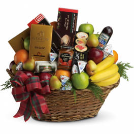 Large wicker gift basket with assorted fruits, cheeses, chocolates, and snacks, topped with a red plaid bow
