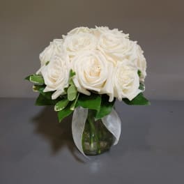 White rose bouquet in a glass vase with a sheer ribbon