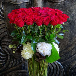 Red roses and white blooms arranged in a clear glass vase