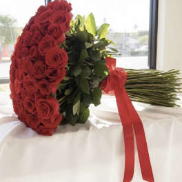 Large bouquet of red roses wrapped with a red ribbon