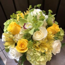 Bouquet of yellow and white roses with green orchids and hydrangeas
