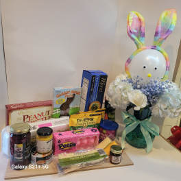 Gift basket with flowers and snacks beside a bunny decoration