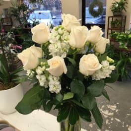 White roses and stock in a clear glass vase