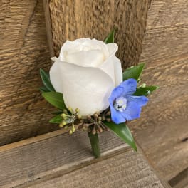 White rose boutonniere with a blue accent flower