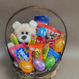 Basket of candy with a teddy bear and colorful Easter eggs