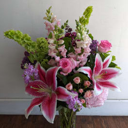 Pink lilies and roses in a clear glass vase