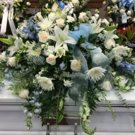 Large white and blue funeral spray on a casket