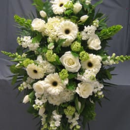 White floral standing spray with roses, gerbera daisies, and greenery