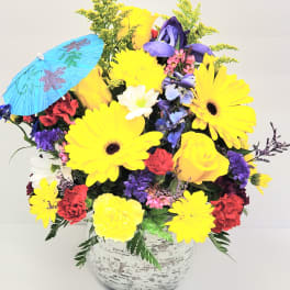 Bright mixed bouquet in a white vase with a blue paper parasol