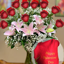 Bouquet of red roses and pink lilies in a glass vase