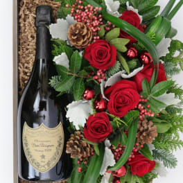 Gift box with a champagne bottle and red rose arrangement