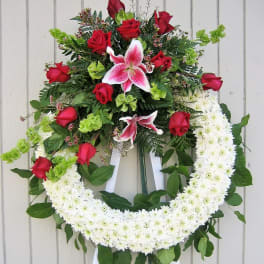 Standing floral wreath with red roses, pink lilies, and white chrysanthemums