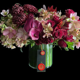 Mixed bouquet of burgundy and pink flowers in a glass vase
