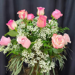 Pink roses in a clear glass vase with white filler flowers