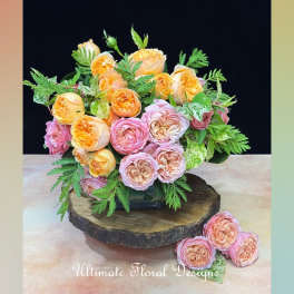 Bouquet of peach and pink roses arranged in a low vase