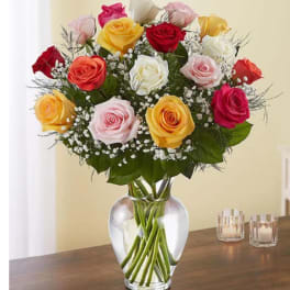 Mixed roses in a clear glass vase with baby's breath
