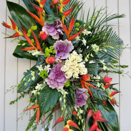 Tropical standing spray with red heliconia, purple cabbage roses, and white roses