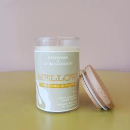 A scented candle in a glass jar with a wooden lid beside it