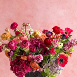 Colorful mixed flower arrangement in a dark vase